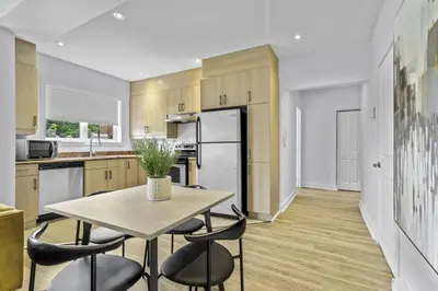 a kitchen with a table and some chairs in it at Stylish 2 Bedroom Haven by Jean Talon Market in Montréal