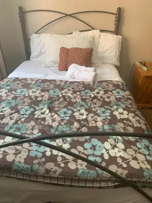 a bed with a brown and white blanket on it at Montréal Steps Downtown Private Rooms in Montréal
