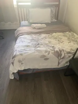 a bed in a room with a wooden floor at Montréal Steps Downtown Private Rooms in Montréal