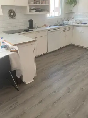 a kitchen with white cabinets and a wooden floor at Montréal Steps Downtown Private Rooms in Montréal