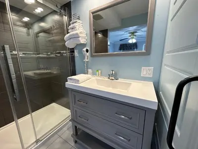a bathroom with a sink and a shower at Motel Le Refuge in Sherbrooke
