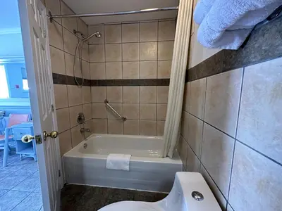 a bathroom with a bath tub and a toilet at Motel Le Refuge in Sherbrooke