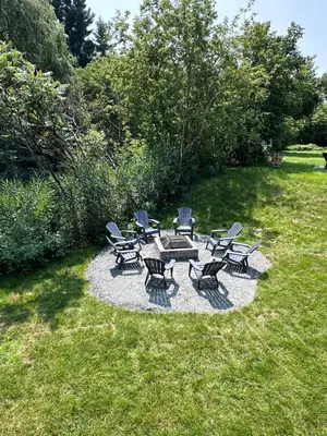 a group of chairs and a picnic table in the grass at L'Escapade - magnifique appartement in Granby