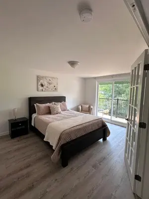 a bedroom with a bed and a large window at Altitude - magnifique logement in Granby