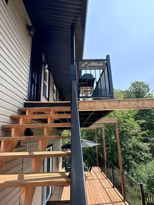 a deck on a house with a surfboard on it at Altitude - magnifique logement in Granby