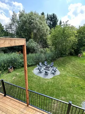 a patio with chairs and a table in a yard at Altitude - magnifique logement in Granby
