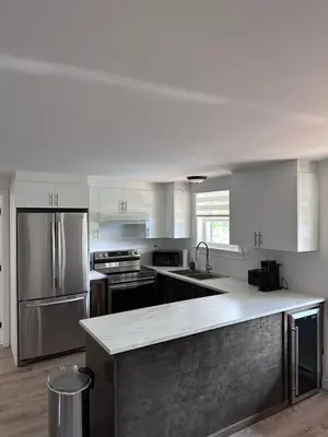 a large kitchen with stainless steel appliances and a counter at Altitude - magnifique logement in Granby