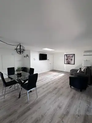 a living room with a table and chairs and a couch at Altitude - magnifique logement in Granby