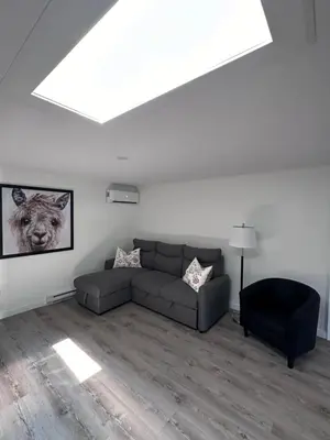 a living room with a couch and a chair at Altitude - magnifique logement in Granby