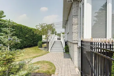 a house with a fence and a walkway at 4 Beds Entire House Wifi Parking in Laval-des-Rapides