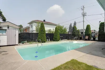a swimming pool in a yard with a house at 4 Beds Entire House Wifi Parking in Laval-des-Rapides