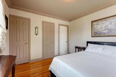 a bedroom with a bed and a painting on the wall at 4 Beds Entire House Wifi Parking in Laval-des-Rapides