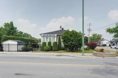 a house on the corner of a street at 4 Beds Entire House Wifi Parking in Laval-des-Rapides