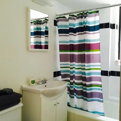 a bathroom with a sink and a shower curtain at Stylish Montreal Apartment Comfortable Stay in the Golden Square Mile in Montréal