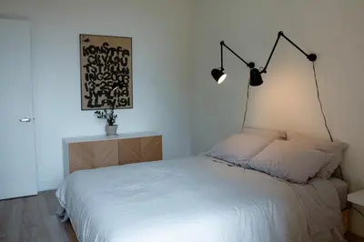 a bedroom with a bed with two lights on the wall at Penthouse with pool and parking in Montréal