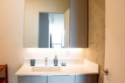 a bathroom with a sink and a mirror at Penthouse with pool and parking in Montréal