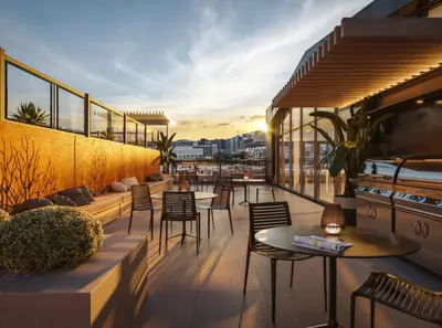 a rooftop patio with tables and chairs on a building at Penthouse with pool and parking in Montréal