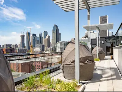 a rooftop patio with a view of a city at Penthouse with pool and parking in Montréal