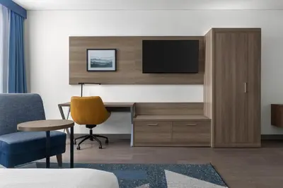 a hotel room with a desk with a tv and a chair at Holiday Inn Express Montreal Airport - St-Laurent by IHG in Montréal