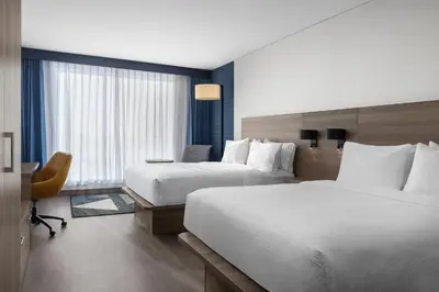 a hotel room with two beds and a desk at Holiday Inn Express Montreal Airport - St-Laurent by IHG in Montréal