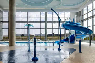 a swimming pool with a water slide in a building at Holiday Inn Express Montreal Airport - St-Laurent by IHG in Montréal
