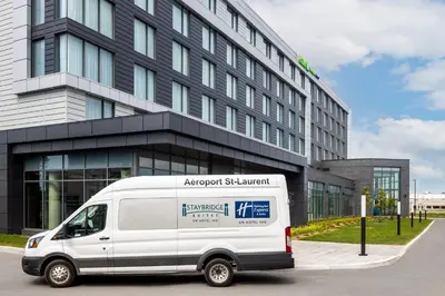 a white van parked in front of a building at Holiday Inn Express Montreal Airport - St-Laurent by IHG in Montréal