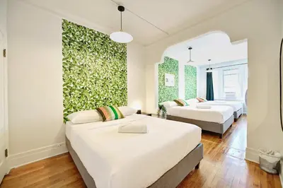 a bedroom with two beds and a green wall at MTLVacationRentals- Le Clebard in Montréal