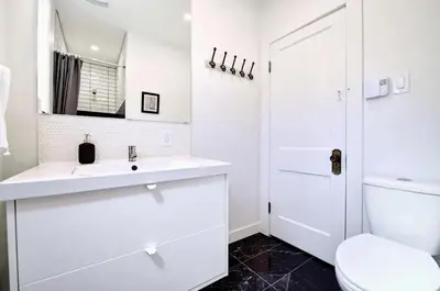 a white bathroom with a sink and a toilet at MTLVacationRentals- Le Clebard in Montréal