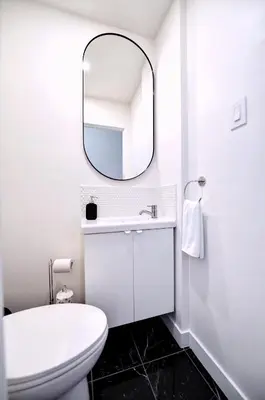 a white bathroom with a sink and a mirror at MTLVacationRentals- Le Clebard in Montréal
