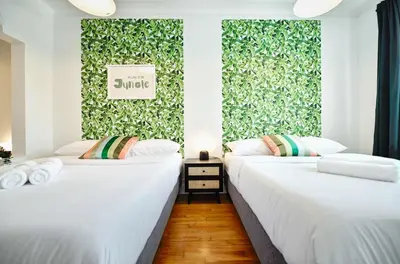 two beds in a room with a green wall at MTLVacationRentals- Le Clebard in Montréal
