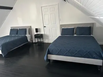 a bedroom with two beds and a white door at La Mezzanine in Granby