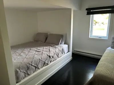 a bed in a room with a window at La Mezzanine in Granby