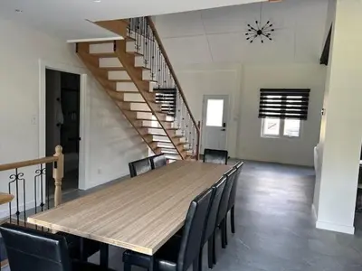 a dining room with a wooden table and chairs at La Mezzanine in Granby