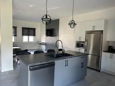 a kitchen with a sink and a stainless steel refrigerator at La Mezzanine in Granby