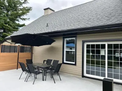a patio with a table and chairs and an umbrella at La Mezzanine in Granby