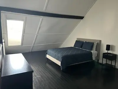 a bedroom with a bed and a window at La Mezzanine in Granby
