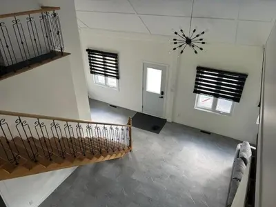 a room with a staircase and a clock on the wall at La Mezzanine in Granby