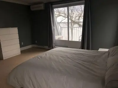 a bedroom with a bed and a large window at Spacious Lakefront Champlain lake with SPA in Venise-en-Québec