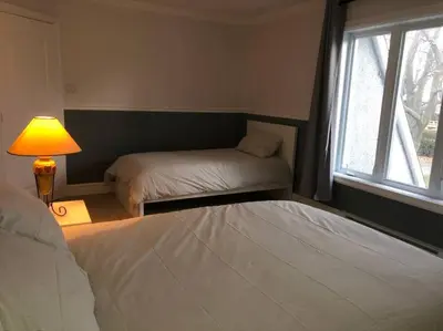 a bedroom with two beds and a lamp and a window at Spacious Lakefront Champlain lake with SPA in Venise-en-Québec