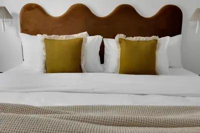 a bed with white pillows and a wooden headboard at The Mercer Boutique Hotel in Montréal