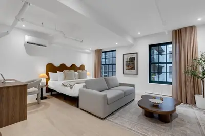 a bedroom with a bed and a couch and a table at The Mercer Boutique Hotel in Montréal