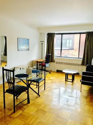 a living room with tables and chairs in a room at Stylish Montreal Apartment Comfortable Stay in the Golden Square Mile in Montréal