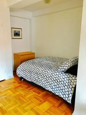 a bedroom with a bed and a wooden floor at Stylish Montreal Apartment Comfortable Stay in the Golden Square Mile in Montréal