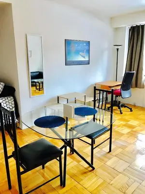 a living room with a glass table and chairs at Stylish Montreal Apartment Comfortable Stay in the Golden Square Mile in Montréal