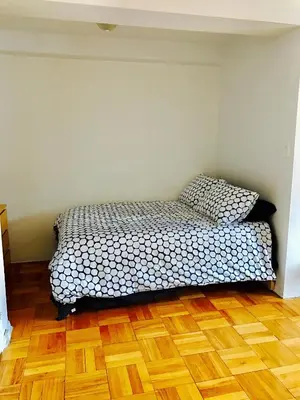 a bedroom with a bed and a wooden floor at Stylish Montreal Apartment Comfortable Stay in the Golden Square Mile in Montréal