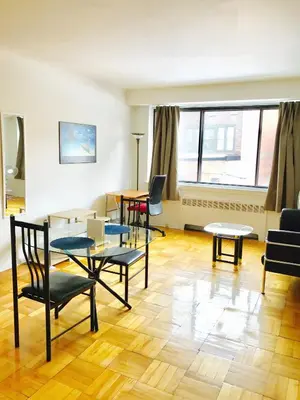 a living room with a table and chairs at Stylish Montreal Apartment Comfortable Stay in the Golden Square Mile in Montréal