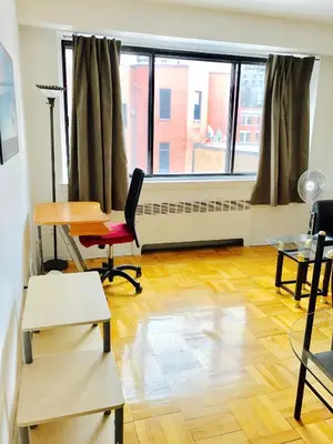 an office with a desk and a chair and a window at Stylish Montreal Apartment Comfortable Stay in the Golden Square Mile in Montréal