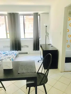 a bedroom with a desk and a bed and a chair at Stylish Montreal Apartment Comfortable Stay in the Golden Square Mile in Montréal