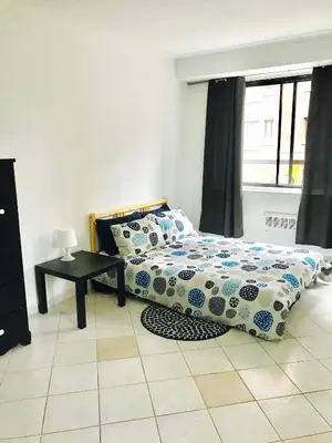 a bedroom with a bed and a table and a window at Stylish Montreal Apartment Comfortable Stay in the Golden Square Mile in Montréal