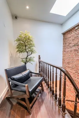 a chair on a staircase with a tree on the wall at Self Check-In Boutique Hotel - Quartier latin - Room 101 in Montréal